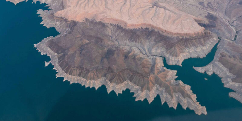 Aerial view of a desert canyon meeting a lake