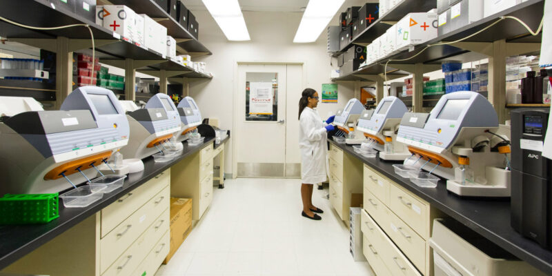Lab technician working among genomic sequencing equipment