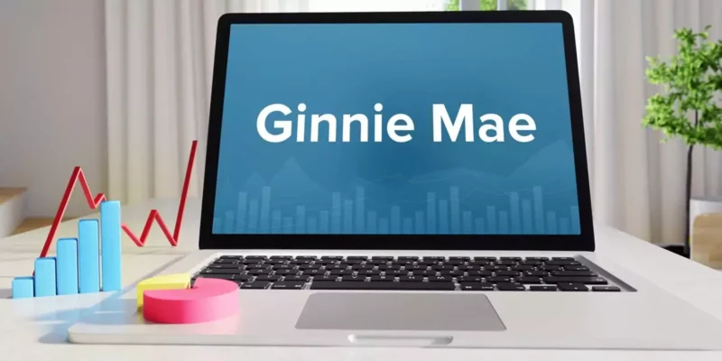 Laptop screen displaying the Ginnie Mae name with financial charts nearby