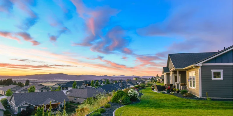 Aerial view of a suburban neighborhood at dusk overlooking mountains